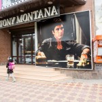 A young girl walking by a men's clothing store named after a Italian mafia character played by Al Pacino.