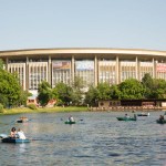 Muscovites paddling in boats in front of Olympiski Stadium, where many top music groups perform.