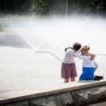 A couple beating the summer heat by sitting in front of a fountain at a Moscow park.