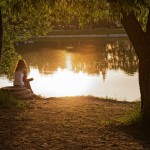 A woman resting a park at sunset.