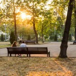 A couple sitting in Luzhniki Park as the sun goes down.