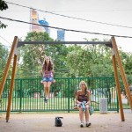Two high school girls enjoying the swings at a Russian park.