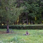 A young Russian man resting with this tablet and headphones in a Moscow park.