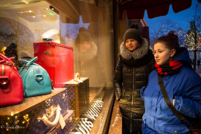 Two girls looking at expensive holiday gifts in GUM shopping window on Red Square. 