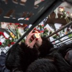 A woman lighting a candle on the bridge during the rally to remember Nemtsov.