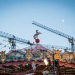 A toy horse figure sits atop a carousel on Red Square as the moon looks down.