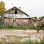 A man dressed in camouflage walking down a road in the Northern Russia village of Tikhmanga. Camouflage is a rather common site in Russian villages.