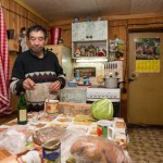 Salavat preparing dinner in the Lunino village home he cares for during the winter months.